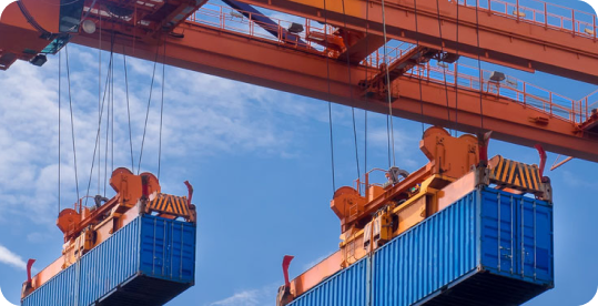 Containers being lifted by cranes at a shipping yard