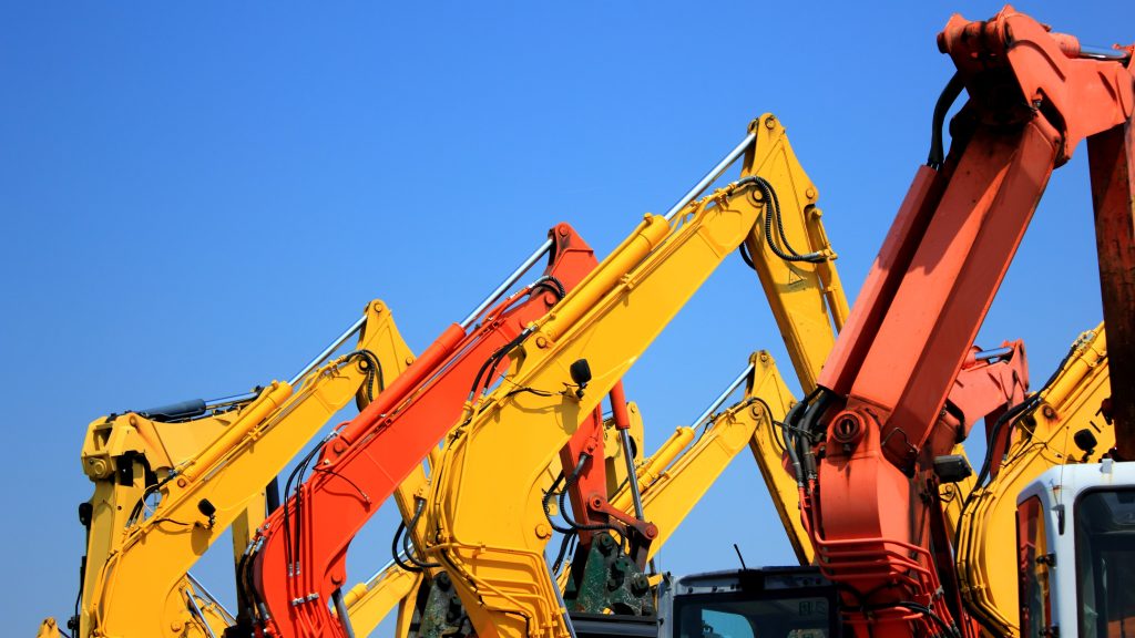 Four digger arms positioned together at a construction site